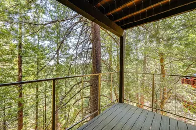 a balcony of a tree house in the woods at Stunning Forest Views Luxury Lake Arrowhead Cabin in Lake Arrowhead