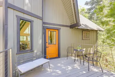 a porch with chairs and a table and a door at Stunning Forest Views Luxury Lake Arrowhead Cabin in Lake Arrowhead