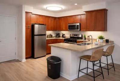 a kitchen with wooden cabinets and a stainless steel refrigerator at Chic Marina 1 Bedroom - Pool - Hot Tub - Gym - Sauna in Los Angeles
