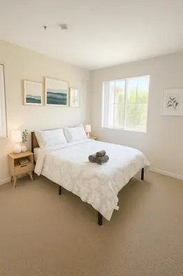 a bedroom with a large white bed with two windows at Chic Marina 1 Bedroom - Pool - Hot Tub - Gym - Sauna in Los Angeles