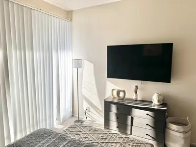 a bedroom with a flat screen tv on a wall at Cozy and Stylish Unit CC 107 in Los Angeles