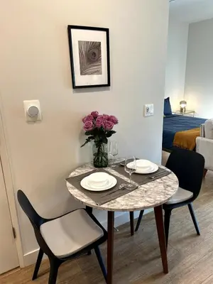 a table with two chairs and a vase of flowers on it at Cozy studio in heart of Santa Monica free parking in Los Angeles