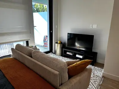 a living room with a couch and a television at Cozy studio in heart of Santa Monica free parking in Los Angeles