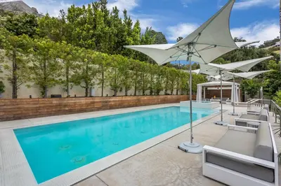 a swimming pool with a white umbrella and chairs at Sunset Strip 5 Star Location w Pool Jacuzzi Cabana BBQ in Los Angeles