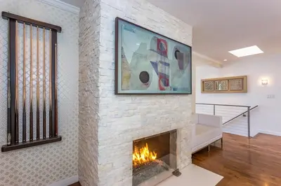 a living room with a fireplace with a painting on the wall at Sunset Strip 5 Star Location w Pool Jacuzzi Cabana BBQ in Los Angeles