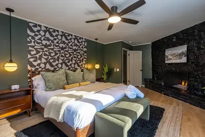 a bedroom with a large bed and a fireplace at Summit Haven: Game Room | Sauna | Spa | 1/4 Acre in Big Bear Lake