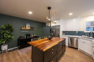 a kitchen with a wooden island in the middle at Summit Haven: Game Room | Sauna | Spa | 1/4 Acre in Big Bear Lake