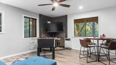 a living room with a tv and a table with a chess game at 5BDR Stay w Fireplace Game room Family-Friendly Amenities Arrowhead Chalet by AvantStay in Lake Arrowhead