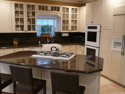 a kitchen with white cabinets and a stove top oven at Private room in guest house - Mini Mansion in Burbank