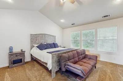 a bedroom with a bed and a couch and windows at Walk to Lake Arrowhead! Family Home with Games in Lake Arrowhead