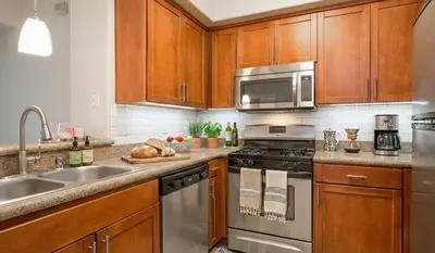 a kitchen with stainless steel appliances and wooden cabinets at Beachside Marina Del Rey 2BR & 1BR - Resort Amenities in Los Angeles