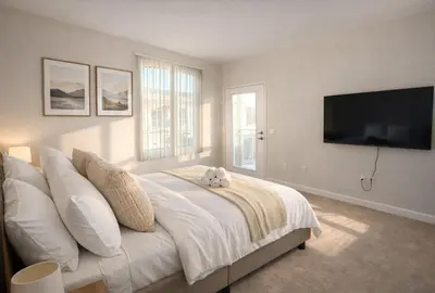 a bedroom with a large white bed with a flat screen tv at Marina Del Rey Beach Retreat w Hot Tub, Billiards & Grill in Los Angeles