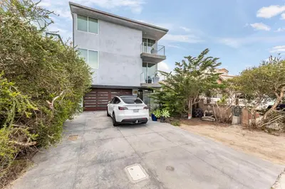 a white car parked in front of a house at ocean front beach house in Oxnard