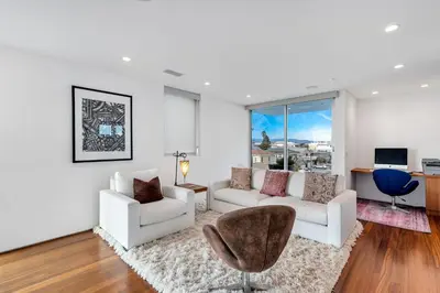 a living room with white furniture and a large window at ocean front beach house in Oxnard