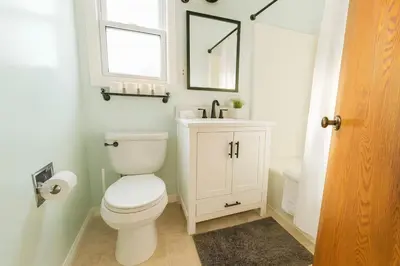 a bathroom with a toilet and a sink and a mirror at 4BR Fullerton Retreat - Private Backyard in Fullerton