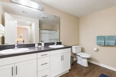 a bathroom with two sinks and a toilet at Serene Zen Peaceful Zen Garden View with Pool Gym in Los Angeles