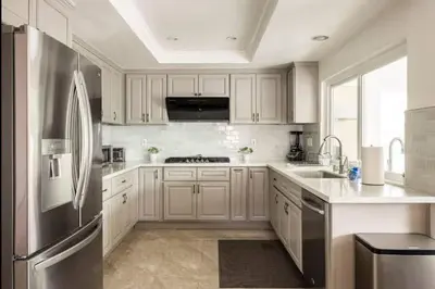 a kitchen with white cabinets and a stainless steel refrigerator at CA1 Fun And Central Home with Sauna in La Palma
