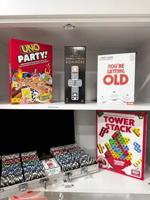 a store shelf filled with boxes of lego party games at The Maze House Pool Theatre Room in San Bernardino