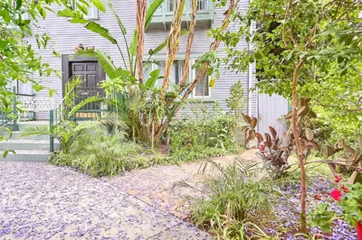 a garden in front of a house with a black door at Iconic Hollywood Homestay Near Walk Of Fame in Los Angeles
