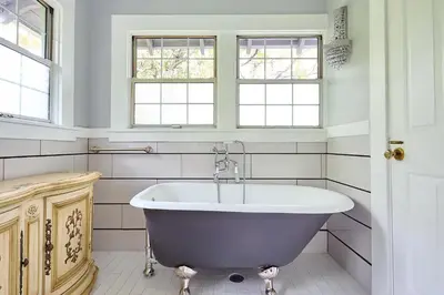 a bath tub in a bathroom with two windows at Iconic Hollywood Homestay Near Walk Of Fame in Los Angeles