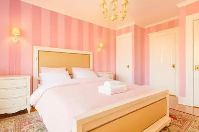 a bedroom with a large white bed with pink stripes at Iconic Hollywood Homestay Near Walk Of Fame in Los Angeles