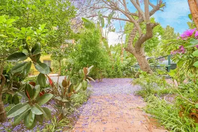 a brick path through a garden with trees and flowers at Central Hollywood Homestay Getaway in Los Angeles