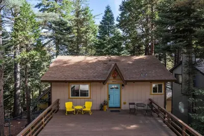 a tiny house with a deck in the woods at Retro Retreat, BBQ, Patio with Outdoor Seating! in Lake Arrowhead