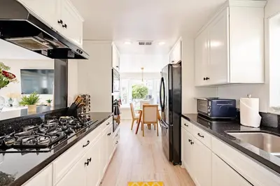 a kitchen with white cabinets and a stove top oven at Amazing location, Unique Oceanfront Beach House! in Manhattan Beach