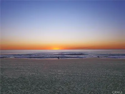 a group of people walking on the beach at sunset at Amazing location, Unique Oceanfront Beach House! in Manhattan Beach