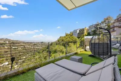 a balcony with a chair and a bird cage at Modern Villa Hollywood Hills Sanctuary in Los Angeles