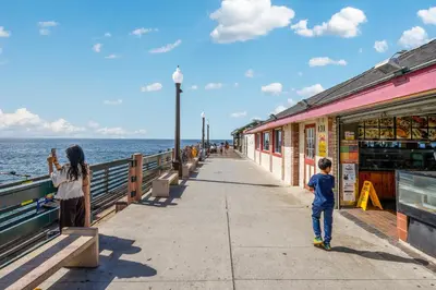 a little boy standing on a sidewalk near the ocean at Oneluxstay 3BR Home Near the Beach in Redondo Beach