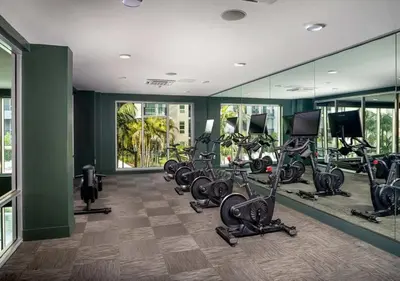 a gym with several treadmills and exercise bikes at Pacific Paradise 10 Min from Disneyland With Pool & GYM in Santa Ana