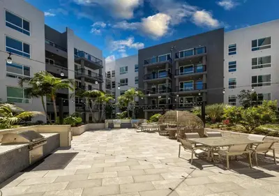 a patio with tables and chairs in front of a building at Premium Stay 10 Min From Disneyland With Pool & GYM in Santa Ana