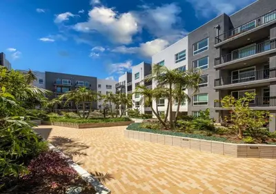 an apartment building with a courtyard with palm trees at Stunning Haven with Pool Gym Parking Close to Disneyland in Santa Ana