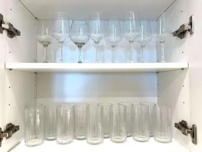 a bunch of wine glasses on shelves in a room at Luxury Haven 10 Min From Disneyland With Pool & GYM in Santa Ana
