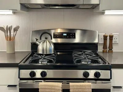 a tea kettle sitting on top of a stove in a kitchen at Modern Retreat 10 Min from Disneyland With Pool & Gym in Santa Ana