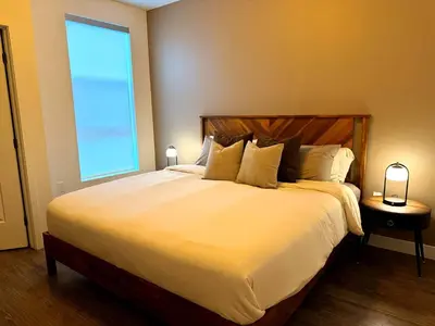 a bedroom with a large bed with a large window at Modern Retreat 10 Min from Disneyland With Pool & Gym in Santa Ana