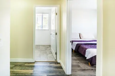 a bedroom with a bed and a door leading into a room at Spacious 5BR 3BA Home with Free Parking and WiFi 10 Minutes to Downtown LA Perfect for Large Groups in Los Angeles