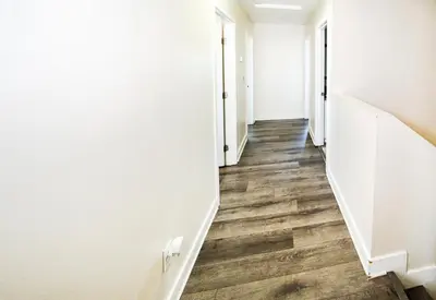 a hallway with white walls and wooden floors at Spacious 5BR 3BA Home with Free Parking and WiFi 10 Minutes to Downtown LA Perfect for Large Groups in Los Angeles