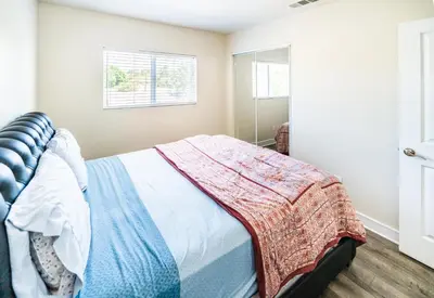 a bedroom with a bed with a blanket on it at Spacious 5BR 3BA Home with Free Parking and WiFi 10 Minutes to Downtown LA Perfect for Large Groups in Los Angeles