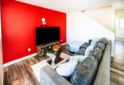 a living room with a couch and a flat screen tv at Spacious 5BR 3BA Home with Free Parking and WiFi 10 Minutes to Downtown LA Perfect for Large Groups in Los Angeles