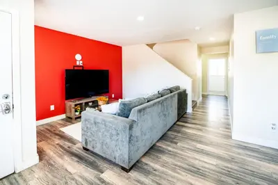 a living room with a couch and a flat screen tv at Spacious 5BR 3BA Home with Free Parking and WiFi 10 Minutes to Downtown LA Perfect for Large Groups in Los Angeles