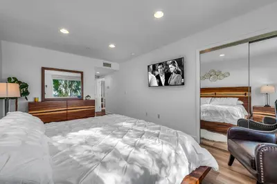 a bedroom with a large white bed and a mirror at Amazing Spacious Unit in Heart of LA- Melrose district in Los Angeles