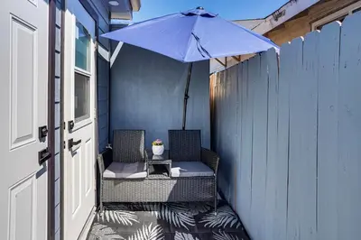 a patio with two chairs and an umbrella at Newly Updated! Commuter-Friendly Anaheim Home in Anaheim