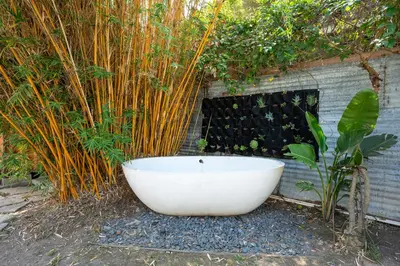 a bath tub sitting on the ground in a garden at Urban Farmhouse in Venice Walk to Abbot Kinney w Patio and Parking in Los Angeles