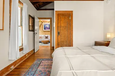 a bedroom with a white bed and a door at Urban Farmhouse in Venice Walk to Abbot Kinney w Patio and Parking in Los Angeles