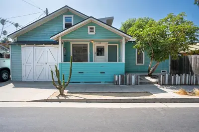 a blue house with a white garage at Urban Farmhouse in Venice Walk to Abbot Kinney w Patio and Parking in Los Angeles