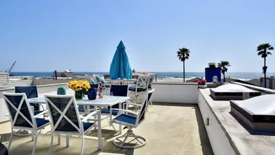 a table and chairs on a balcony with a view of the ocean at Luxury, Beach House, and quiet neighborhood in Oxnard
