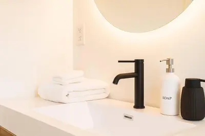 a bathroom sink with a soap dispenser and a mirror at South Pasadena Studio Spa Escape in South Pasadena