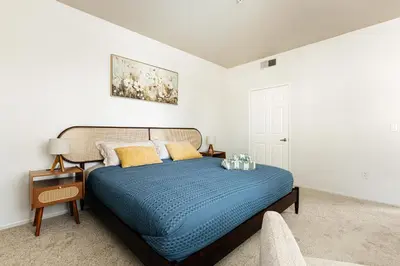 a bedroom with a bed with a blue comforter at Pearl 2B apartment in Marina with parking, Pool and Gym in Los Angeles